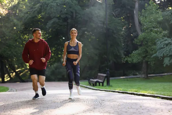 Dışarıda profesyonel antrenörle koşan genç bir kadın. Metin için boşluk