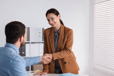 İş ortakları masa içinde el sıkışıyor, mesaj için yer var.