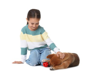 Gülümseyen küçük kız ve köpeği beyaz arka planda evcil oyuncağıyla
