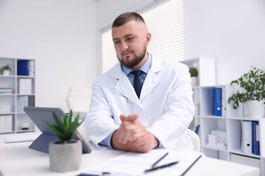 Doktor içeride tabletle çevrimiçi danışmanlık yapıyor.