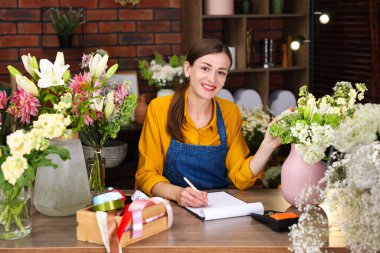 Dükkandaki ahşap masada çalışan profesyonel bir çiçekçi.