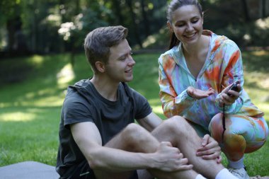 Genç adam profesyonel antrenörle dışarıda egzersiz yapıyor.