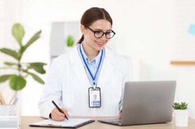 Teletıp. Doktor içeride bilgisayarla hastayla görüntülü konuşma yaparken not alıyor.