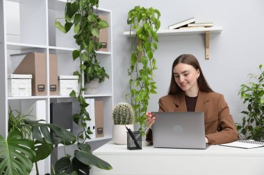 Ofiste bilgisayarla görüntülü konuşma yapan bir kadın.