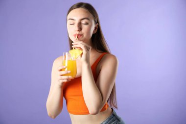 Kadın menekşe arka planında samandan meyve suyu içiyor.