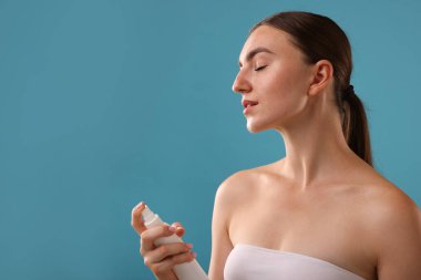 Güzel bir kadın açık mavi arka planda termal su püskürtüyor. Metin için boşluk