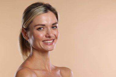 Bej arka planda sağlıklı dişleri olan güzel bir kadın. Metin için boşluk