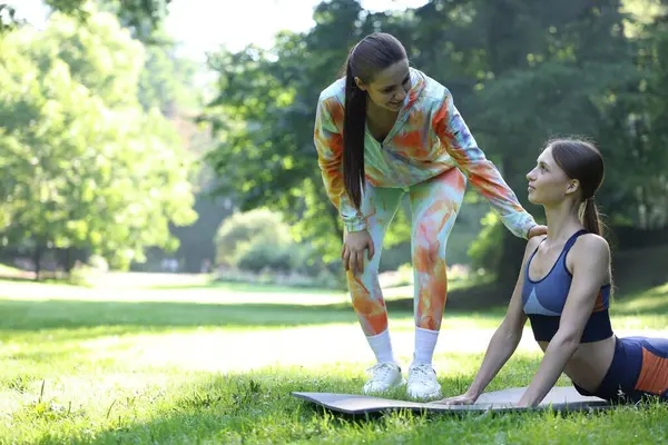 Dışarıda profesyonel antrenörle egzersiz yapan genç bir kadın. Metin için boşluk