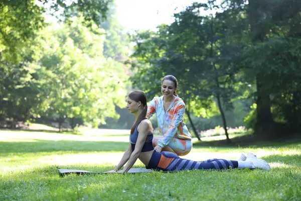 Dışarıda profesyonel antrenörle egzersiz yapan genç bir kadın.