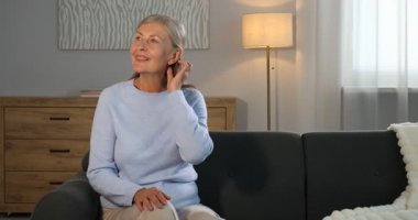 Evdeki kanepede son sınıf öğrencisi zarif bir kadın.