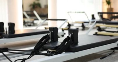 Stüdyoda yenilikçi makineler, kamera sağa hareket ediyor. Pilates ekipmanı