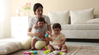 Annem evde sevimli küçük ikizleri ve oyuncaklarıyla