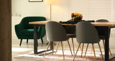 Yemek odasındaki ahşap masada bir kase meyve. Kamera sağa hareket ediyor