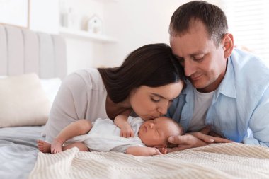 Anne ve baba yeni doğmuş bebekleriyle evde yatıyorlar.