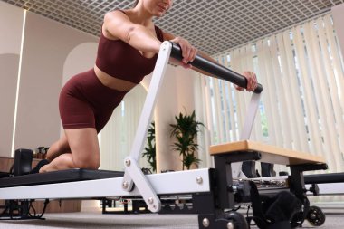 Pilates stüdyosunda yenilikçi kadın egzersizi, yakın çekim.