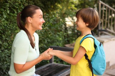 Anne oğlunu açık hava okuluna götürüyor.