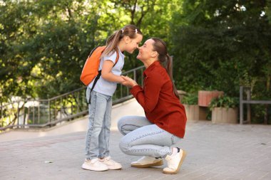 Anne kızını açık hava okuluna götürüyor.