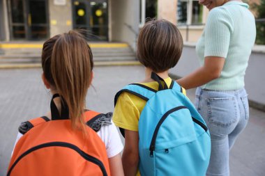 Anne çocuklarını açık hava okuluna götürüyor.