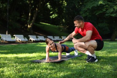 Dışarıda profesyonel antrenörle egzersiz yapan genç bir kadın. Metin için boşluk