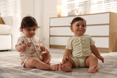 Evde yerde tatlı küçük ikiz bebekler
