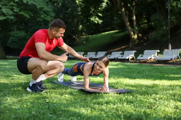Dışarıda profesyonel antrenörle egzersiz yapan genç bir kadın. Metin için boşluk