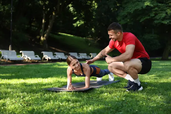 Dışarıda profesyonel antrenörle egzersiz yapan genç bir kadın. Metin için boşluk