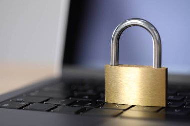 Siber güvenlik. Metal asma kilit ve dizüstü bilgisayar masada, yakın plan. Metin için boşluk