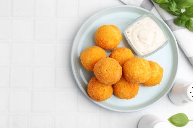 Lezzetli kızarmış köfteler, sos ve fesleğen, açık fayanslı masa, düz yatak. Metin için boşluk