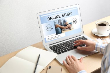 Çevrimiçi çalışma. Masada e-öğrenim için dizüstü bilgisayar kullanan kadın, yakın plan