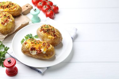 Beyaz ahşap masada lezzetli fırınlanmış patatesler, yazı için yer.