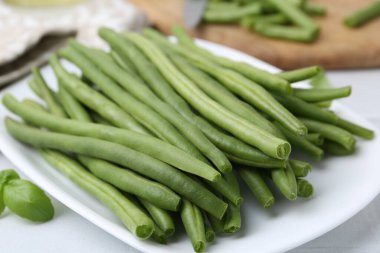 Fresh green bean pods on white table, closeup