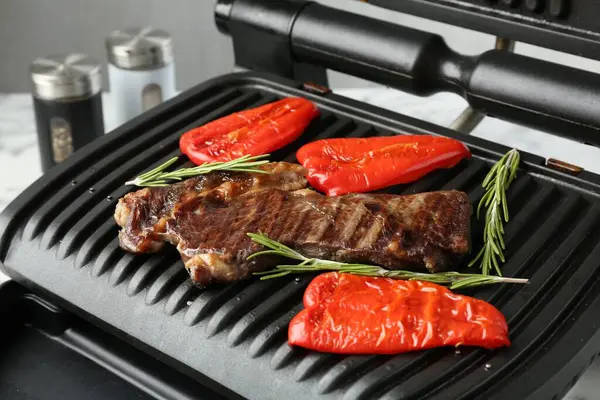 Biftekli ızgara, dolmalık biber ve biberiye beyaz masada, yakın plan.