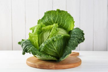 Beyaz ahşap masada taze bir Savoy lahanası.