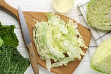 Taze kesilmiş Savoy lahanası ve bıçağı beyaz masada, düz yatıyordu.