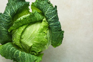 Fresh Savoy cabbage on light grey table, top view. Space for text