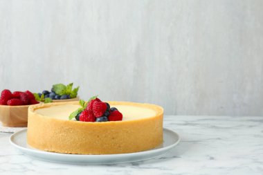 Taze böğürtlenli nefis cheesecake ve beyaz mermer masa üzerinde nane, metin için yer