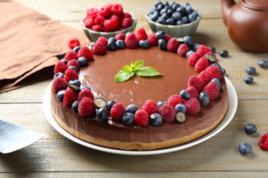 Lezzetli çikolatalı kek, böğürtlenli ve nane şekerli, ahşap masa, yakın plan.