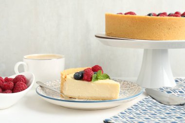 Taze böğürtlenli ve beyaz masada servis edilen nefis peynirli kek.