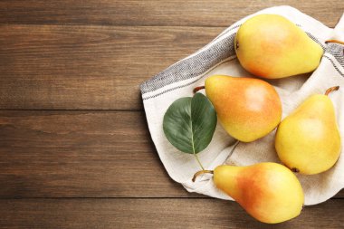 Bir sürü taze armut ve peçete, ahşap masa, üst manzara. Metin için boşluk