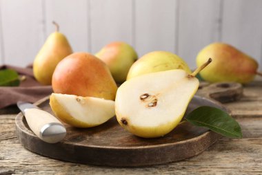 Taze armutlar ve bıçaklar ahşap masada, yakın plan.