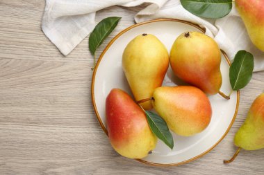 Taze armutlar ve ahşap masanın üzerinde yeşil yapraklar. Metin için boşluk