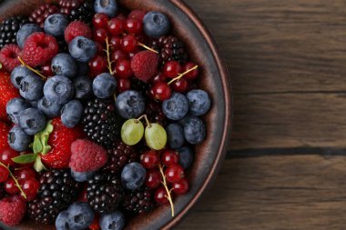 Tahta masadaki kasede farklı olgun böğürtlenler, üst manzara. Metin için boşluk
