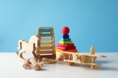 Beyaz masada açık mavi arka planda farklı sevimli oyuncaklar