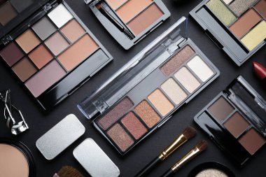 Göz falı paletleri, diğer kozmetik ürünler ve siyah arkaplan fırçaları, düz yatıyordu