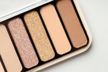 Beautiful eyeshadow palette on white table, top view