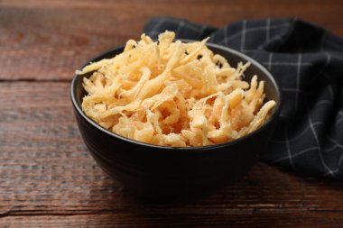 Ahşap masada, tabakta kurutulmuş mürekkep balığı talaşı, yakın plan.