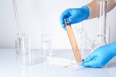 Bilim adamı kirli suyu beyaz masada test ediyor, yakın plan.