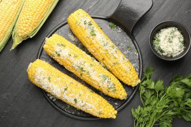 Siyah masada maydanozlu ve peynirli mısır koçanlarının tadı açık.