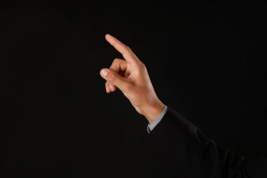 Siyah arka planda bir şeye dokunan adam, yakın plan. Metin için boşluk