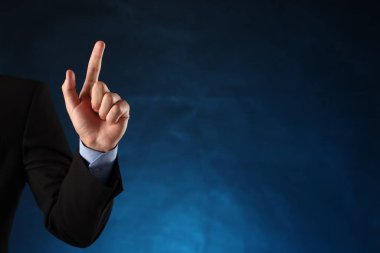 Adam mavi arkaplanda bir şeye dokunuyor, yakın plan. Metin için boşluk